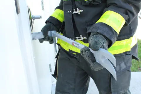 Firefighter using Halligan bar to force a door